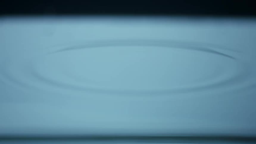 Droplet falls into the water and creates ripples