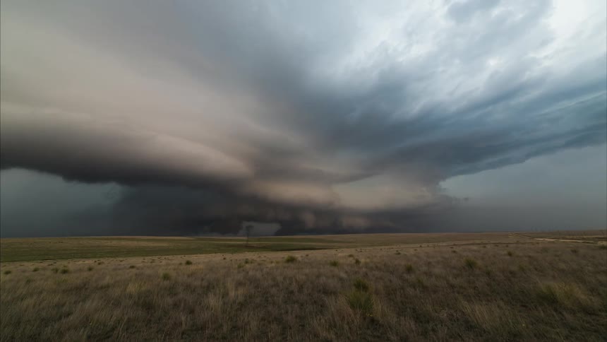 Time lapse of a large field as a tornado forms ahead