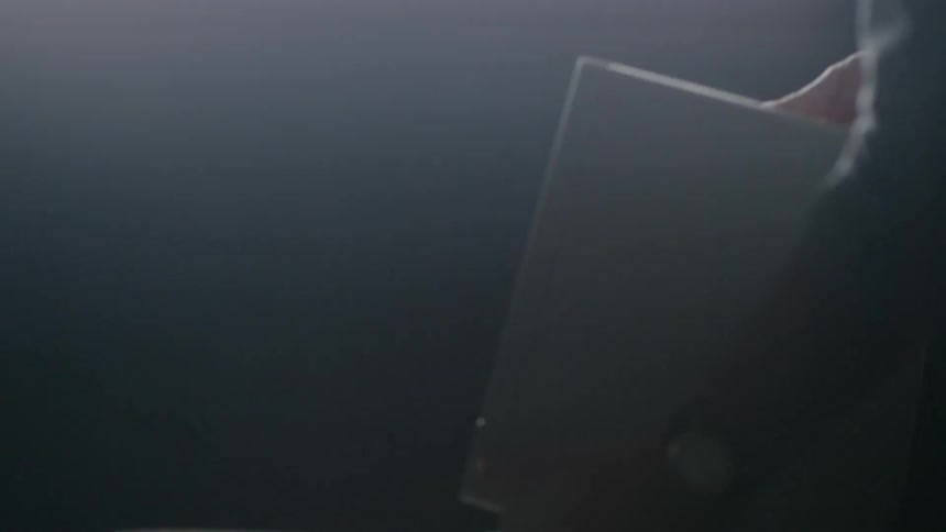 A man places an old computer on a desk
