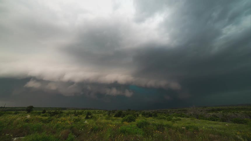 Storm clouds rolling into the skies above a hilly grassland