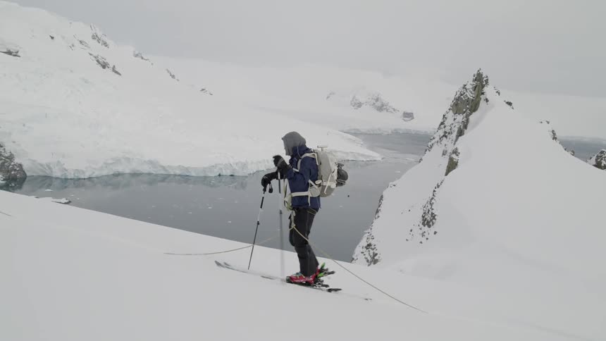 A group of adventure skiers skin up the ridge in Antarctica