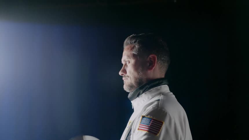 An astronaut puts on a helmet
