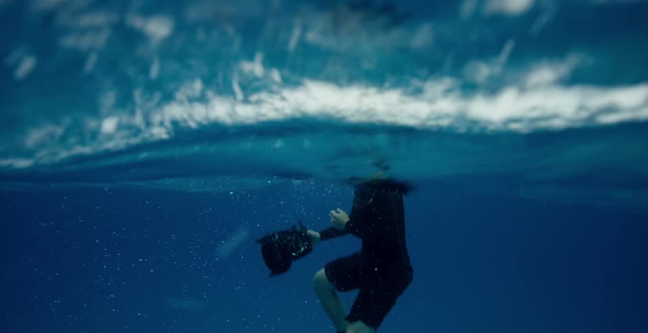 The diver floats in the water near the surface recording