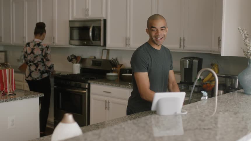 A man and woman cook and wash dishes in a kitchen