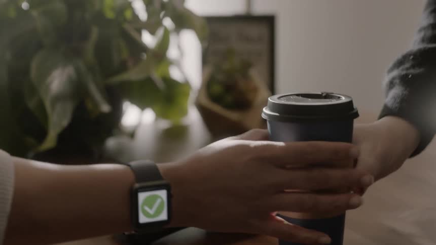 A man pays for a coffee with his smart watch