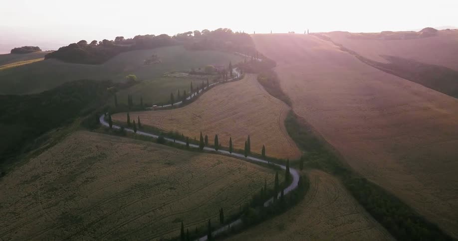 The curving road lines the hill below