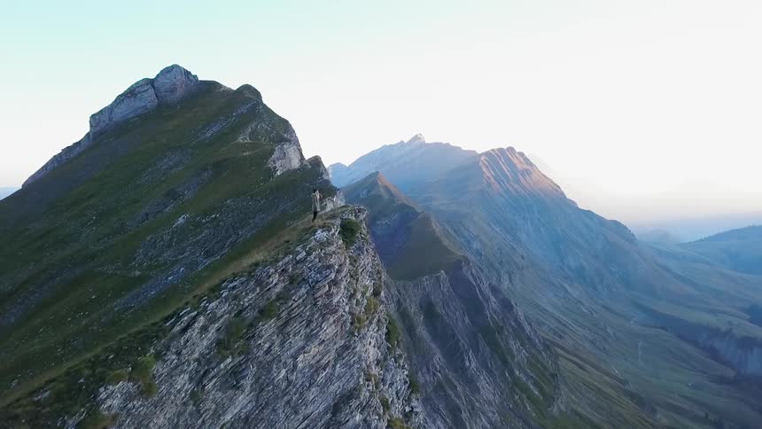 A person stands on the top of the mountain