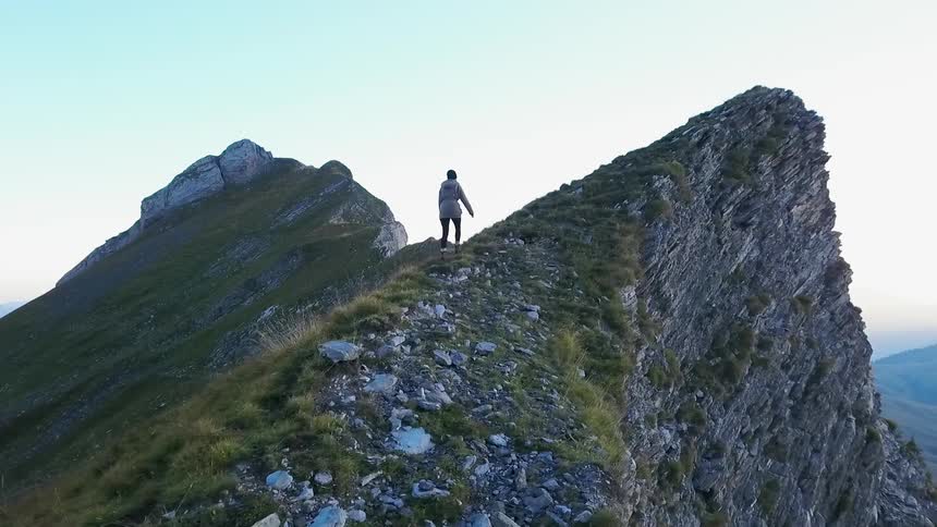 A hiker climbs up a mountain peak
