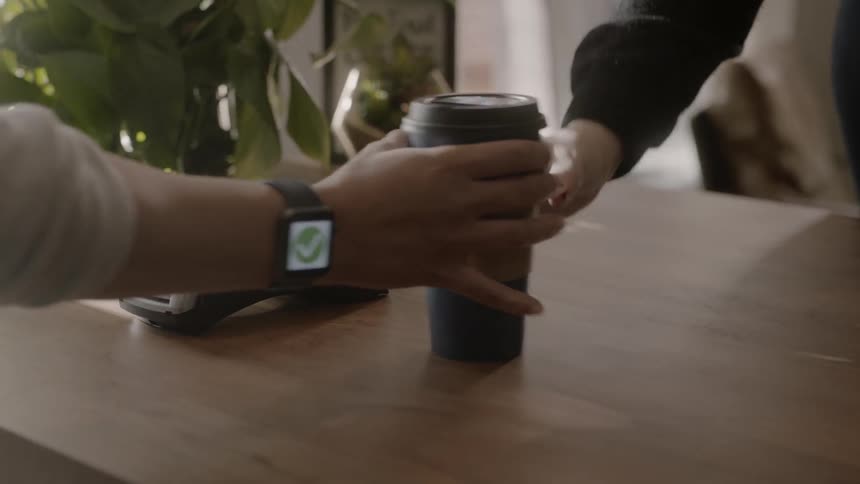 Batista hands a coffee to a customer