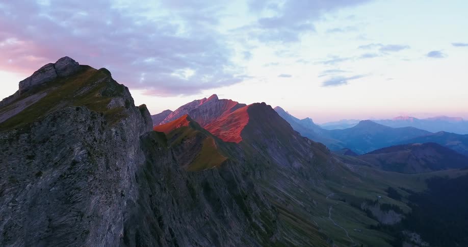 The sun is setting over the hill of the tall mountain