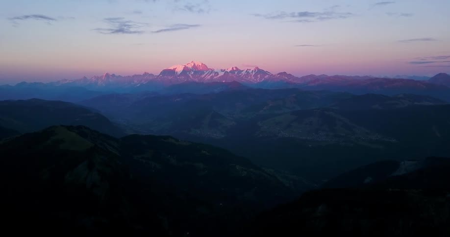 Dusk is falling over a snow-covered mountain range