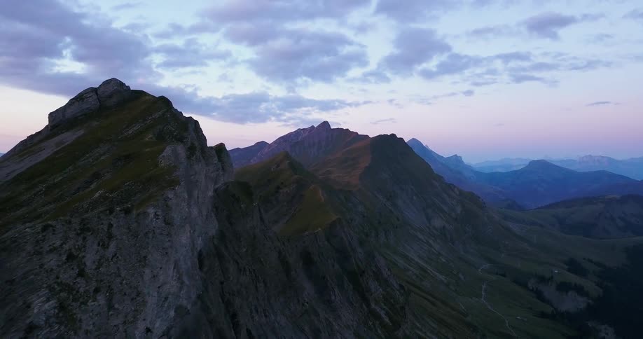 Clouds float above mountains at sunrise