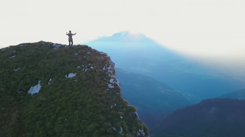 A person takes in the view from the very top of the mountain