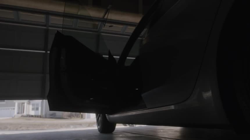 Person opens a car door and gets in as the garage door opens