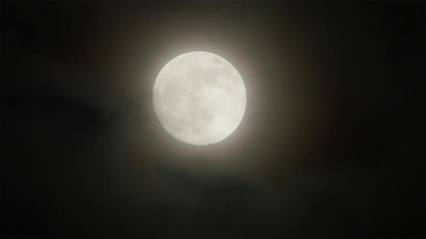 Clouds float in front of the moon