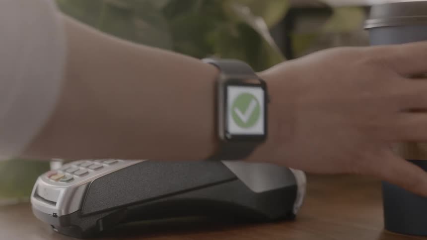 A man pays for coffee with a smartwatch