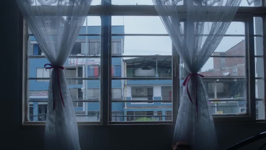 Out of the window is a row of apartment buildings
