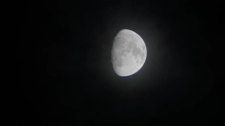 Moon sits in the sky partially covered by a shadow