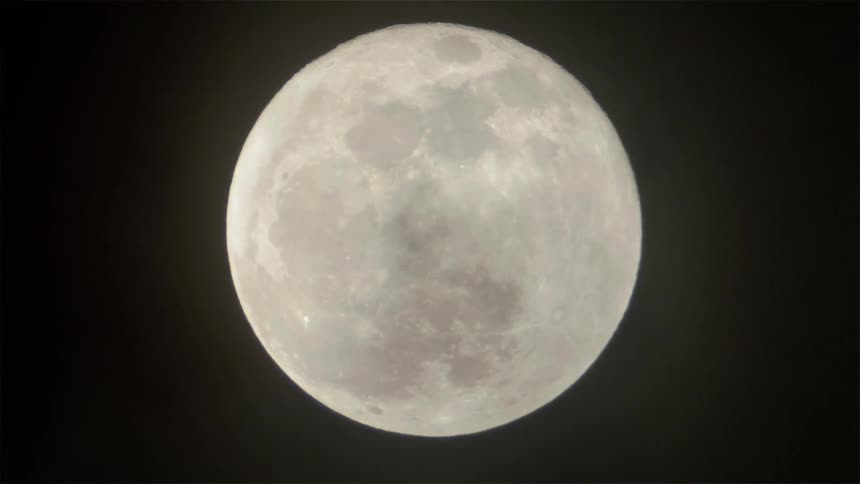 Clouds float in front of the moon