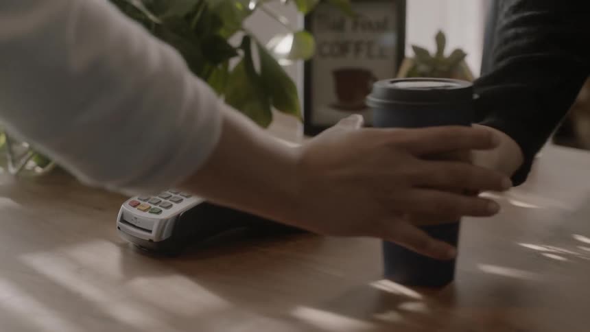 A person scans their phone on the machine and receives a beverage