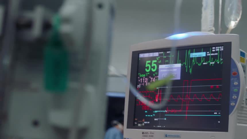 A medical monitor in a hospital is flashing vitals