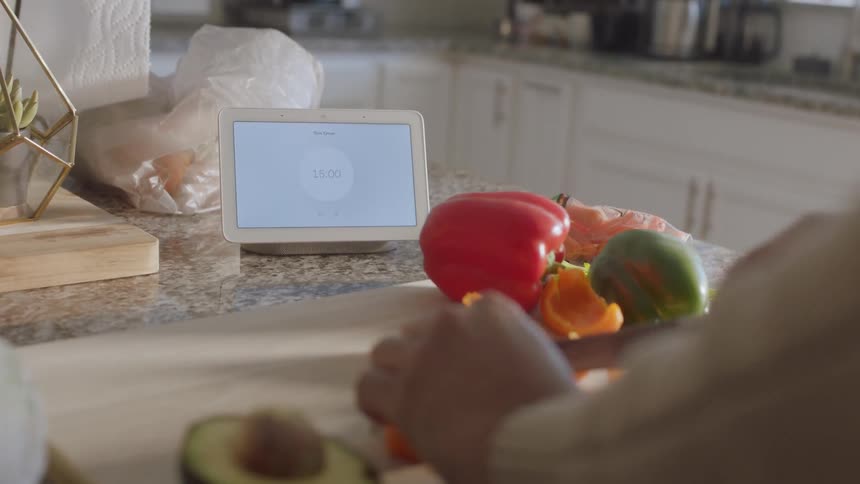 Person cuts vegetables on a cutting board in the kitchen