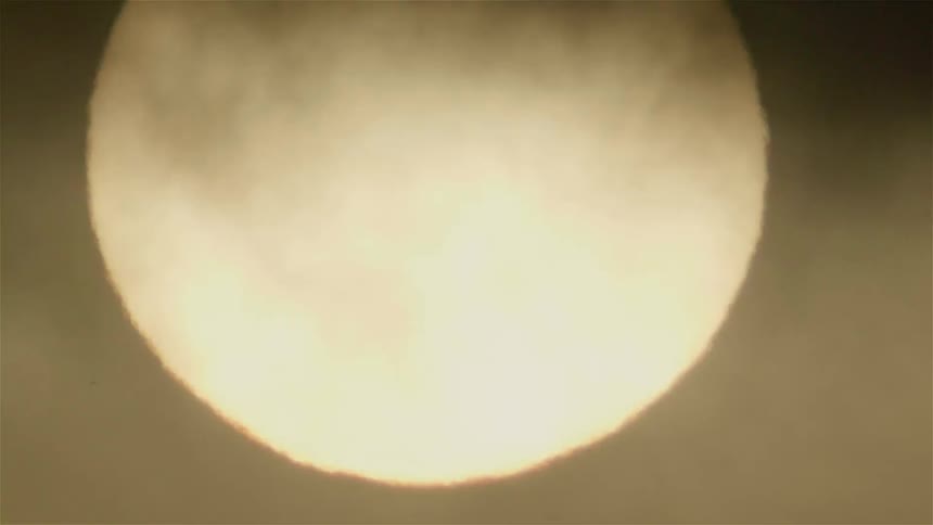 Clouds float in front of the sun