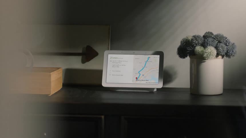 Person walks by a counter and picks up an item that's sitting in front of a tablet