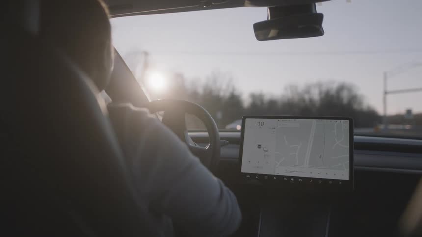 Man turns the steering wheel as he drives a vehicle