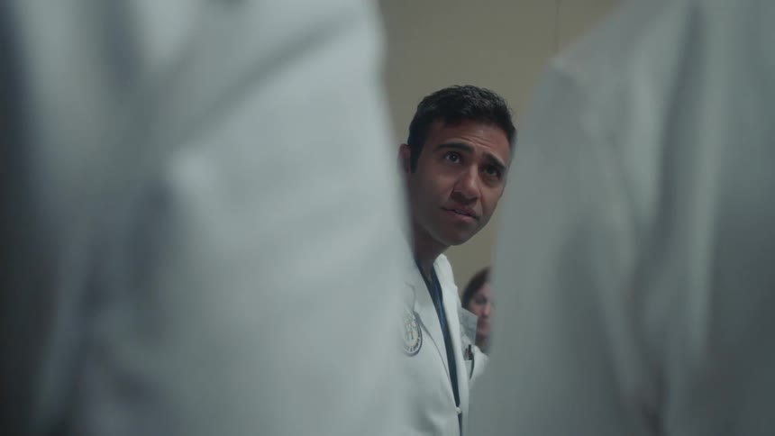 Team of doctors stand around talking
