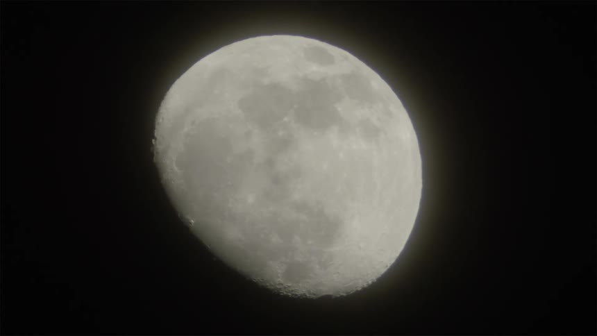 The moon glows in the night sky