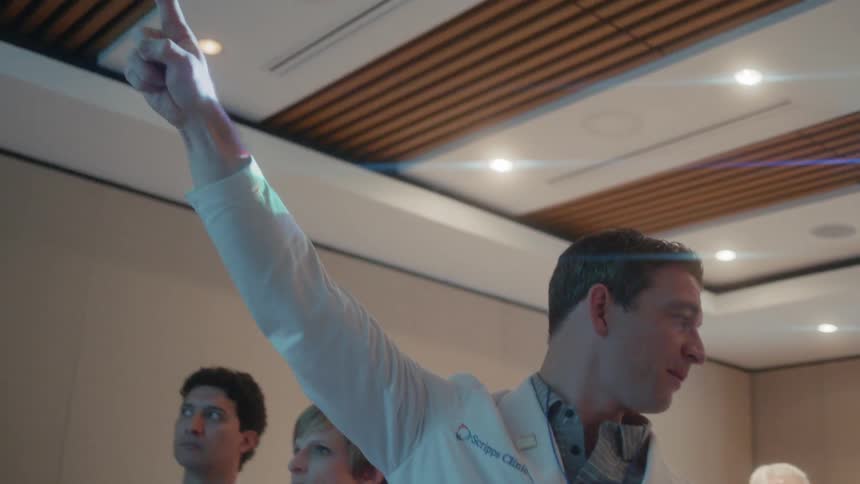 Man talks and points upwards by a group of people