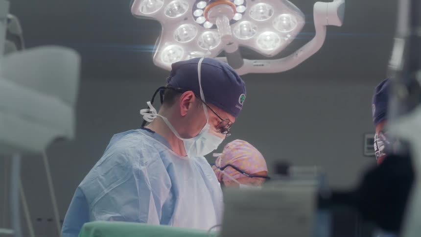 The doctors surround the patient in the operating room
