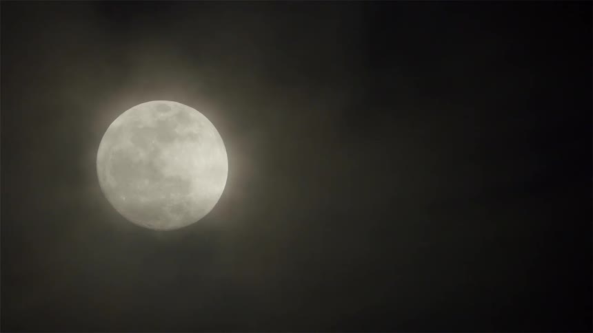 Clouds float in front of the moon