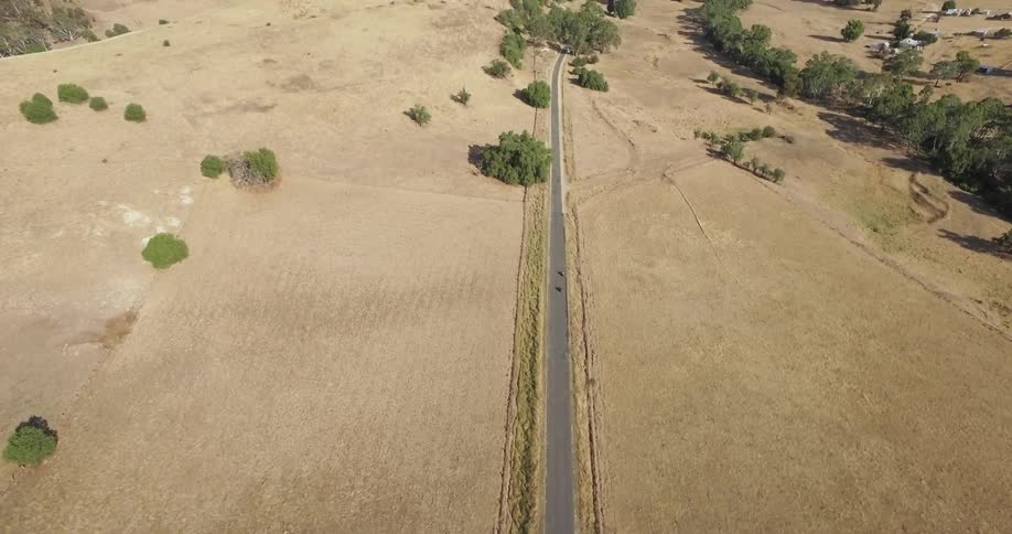 A vehicle travels down the small road down the valley