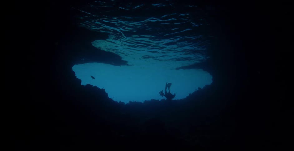 Underwater diver swims near the ocean floor
