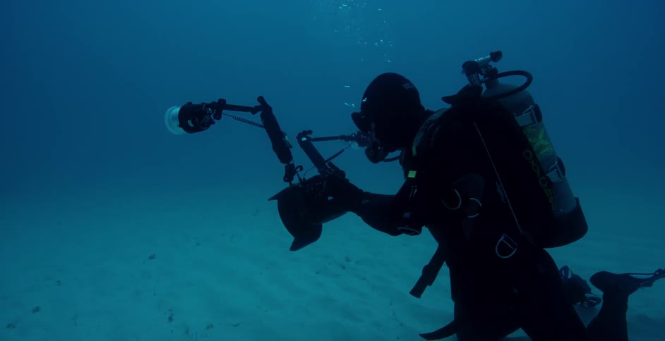 The scuba diver takes a photo underwater