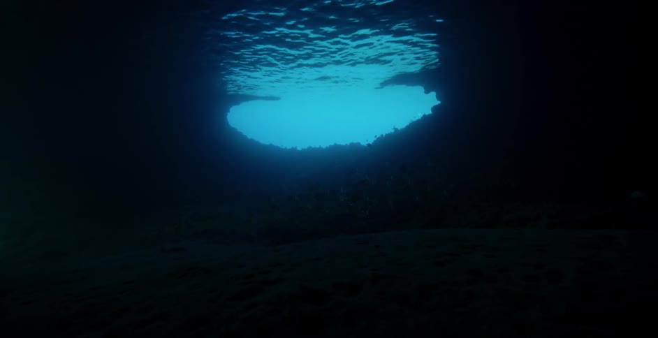 The sunlight shines near the opening of an underwater cavern