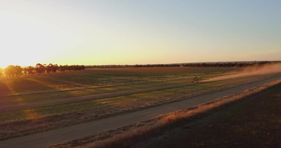 Airplane takes off on a dirt path in a large field