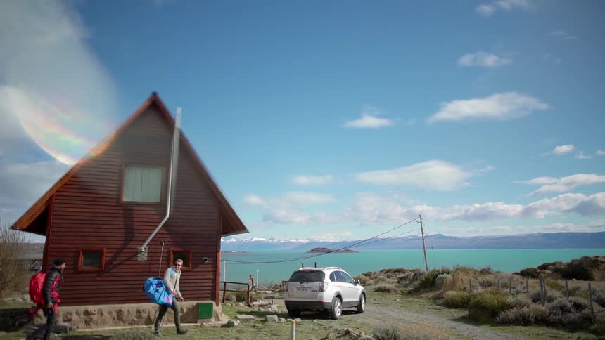 A group of people walk toward an suv near a house
