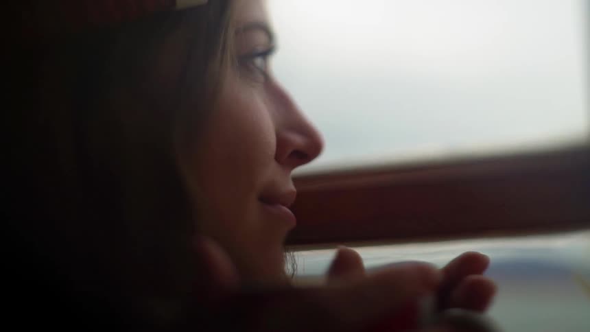 A woman looks out a window