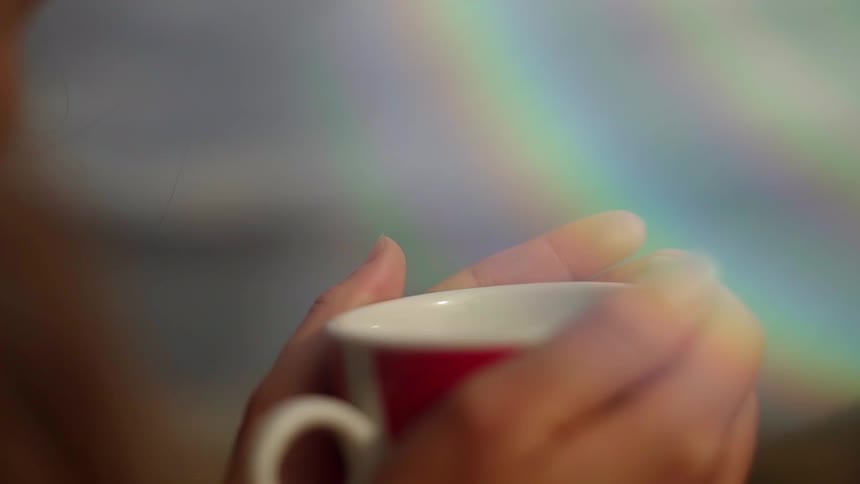 A woman holds a mug with both hands