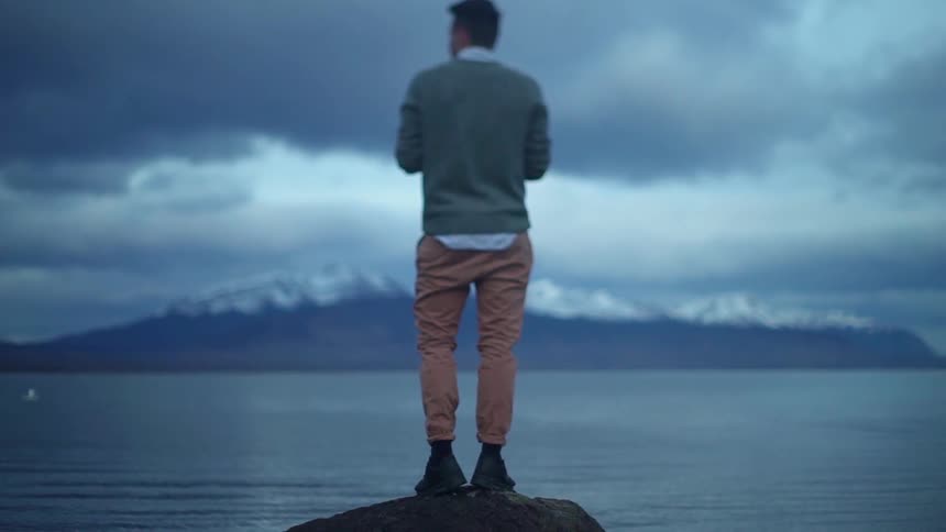 Man stands alone as he looks out at the lake