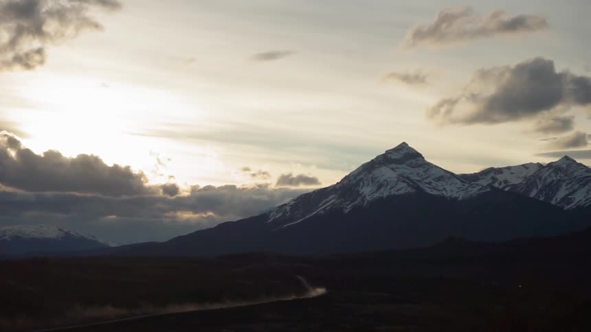 The sun sets over snowy mountains