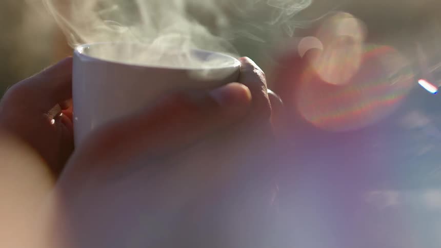 Person holds a steaming mug
