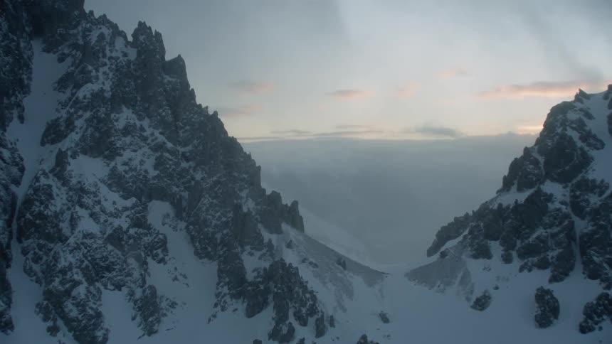 The tall mountain is covered with fog and snow