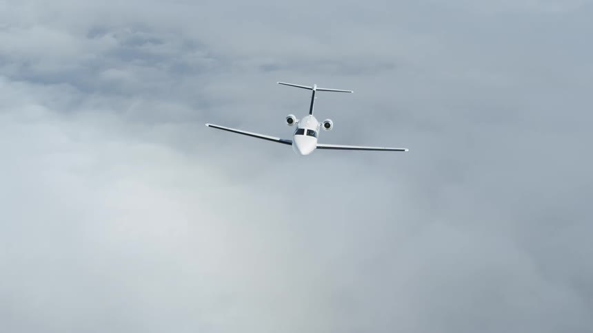 A luxury jet is flying above the clouds during the day