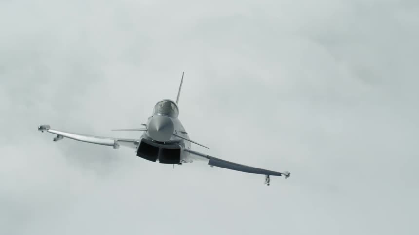 A jet flies above clouds in the sky