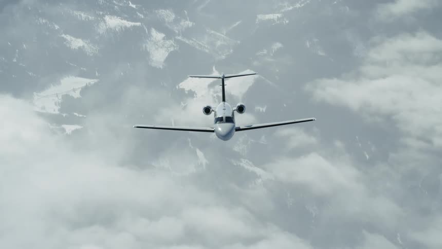 A jet flies above the clouds and snow covered landscape