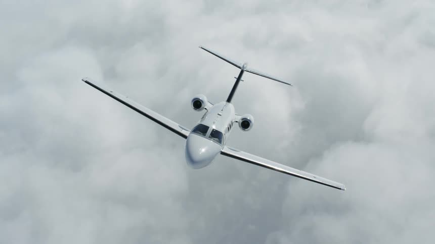 A jet flies above clouds in the sky